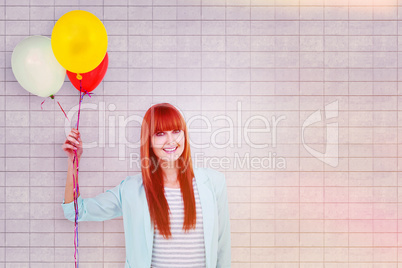 Composite image of smiling hipster woman holding balloons