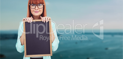 Composite image of smiling hipster woman holding blackboard