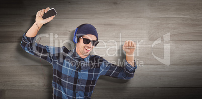 Composite image of portrait of happy hipster wearing headphones
