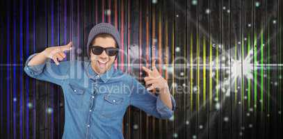 Composite image of happy hipster showing rock and roll hand sign