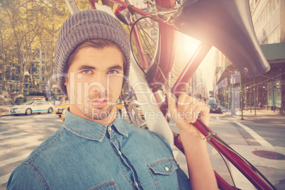 Composite image of portrait of hipster carrying bicycle