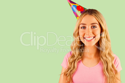 Composite image of portrait of a beautiful woman with party hat