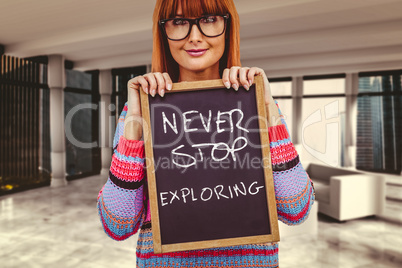 Composite image of smiling hipster woman holding blackboard