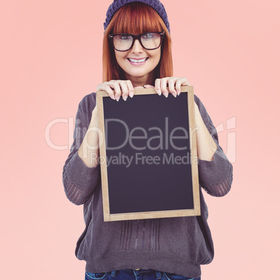 Composite image of smiling hipster woman holding blackboard