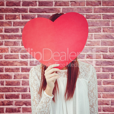 Composite image of smiling hipster woman behind a big red heart