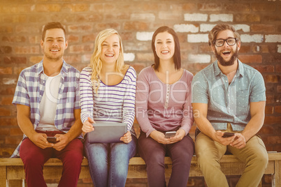 Composite image of portrait of smiling business people holding e