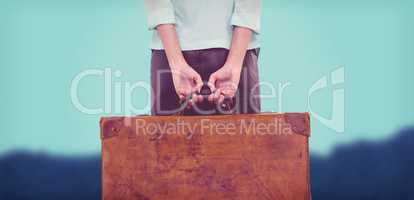 Composite image of rear view of hipster woman holding suitcase