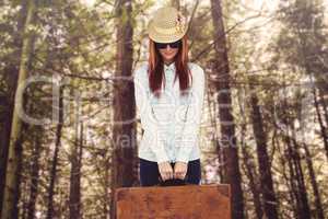 Portrait of a hipster woman holding suitcase