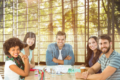 Composite image of happy creative business team looking at the c