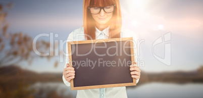 Composite image of smiling hipster woman holding blackboard