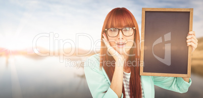 Composite image of smiling hipster woman holding blackboard