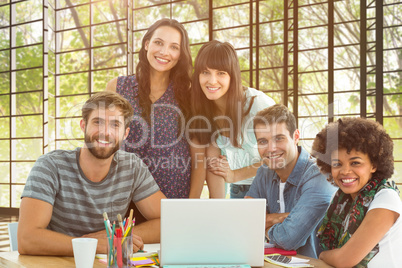 Composite image of happy creative business team gathered around