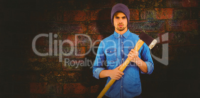 Composite image of portrait of serious hipster holding axe