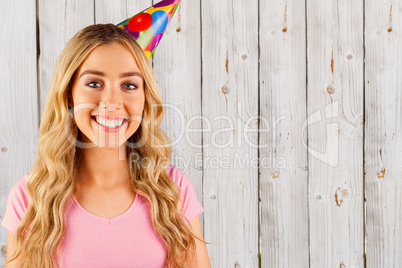 Composite image of portrait of a beautiful woman with party hat