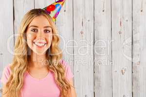 Composite image of portrait of a beautiful woman with party hat