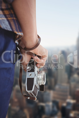 Composite image of cropped image of man holding camera