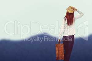 Composite image of rear view of hipster woman holding suitcase