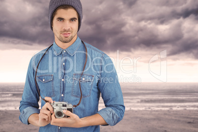 Composite image of portrait of confident  hipster using camera