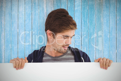Composite image of man holding billboard