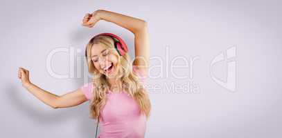 Composite image of beautiful woman dancing with headphones