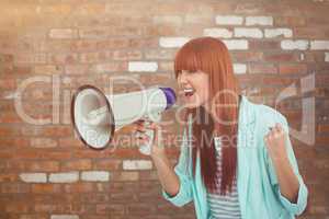 Composite image of hipster woman shooting through megaphone