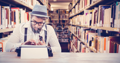 Composite image of hipster smoking pipe while working at desk