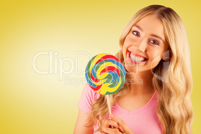 Composite image of a beautiful woman holding a giant lollipop