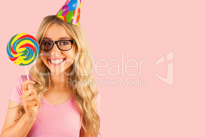 Composite image of portrait of a hipster with a party hat holdin