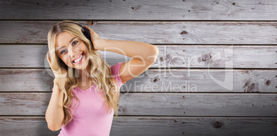 Composite image of portrait of a beautiful woman dancing with headphones