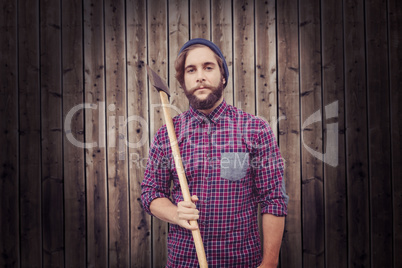 Composite image of portrait of hipster holding axe