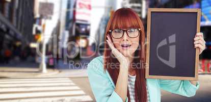 Composite image of smiling hipster woman holding blackboard