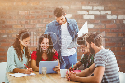 Composite image of creative business team gathered around a tabl