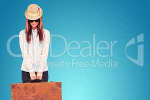 Composite image of portrait of a hipster woman holding suitcase