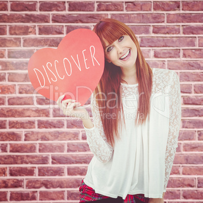 Composite image of smiling hipster woman with a big red heart