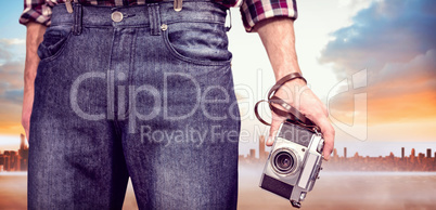 Composite image of hipster man holding digital camera