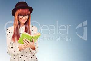 Composite image of hipster woman reading a green book