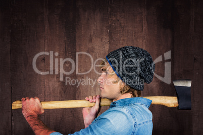 Composite image of side view of hipster standing with axe