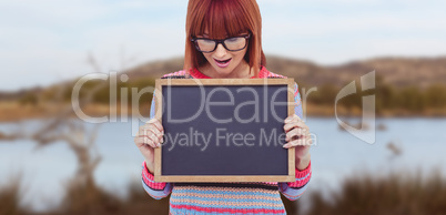 Composite image of smiling hipster woman holding blackboard