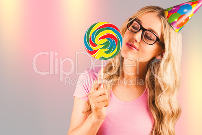 Composite image of a beautiful hipster holding a giant lollipop