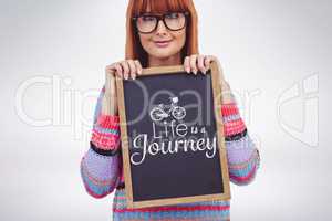 Composite image of smiling hipster woman holding blackboard