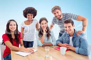 Composite image of smiling creative business team looking at the