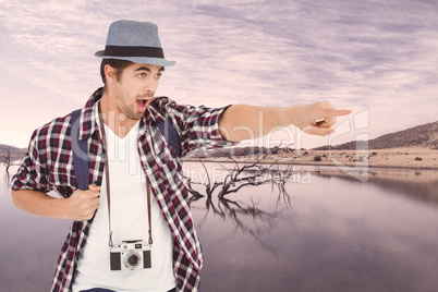 Composite image of surprised man with backpack pointing