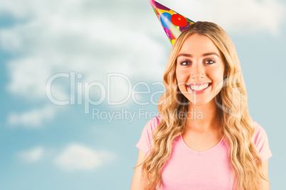 Composite image of portrait of a beautiful woman with party hat