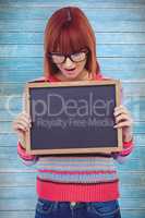 Composite image of smiling hipster woman holding blackboard