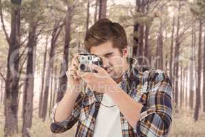 Composite image of hipster photographing against wooden wall