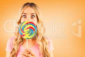 Composite image of a beautiful woman holding a giant lollipop