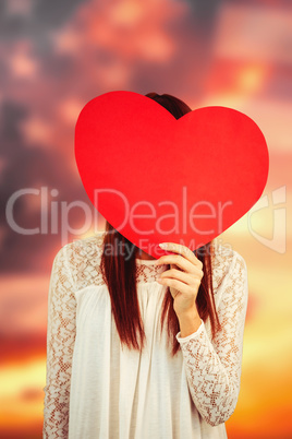 Composite image of smiling hipster woman behind a big red heart