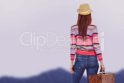 Composite image of rear view of a hipster woman holding suitcase