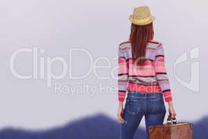 Composite image of rear view of a hipster woman holding suitcase