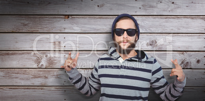 Composite image of hipster showing rock and roll hand sign